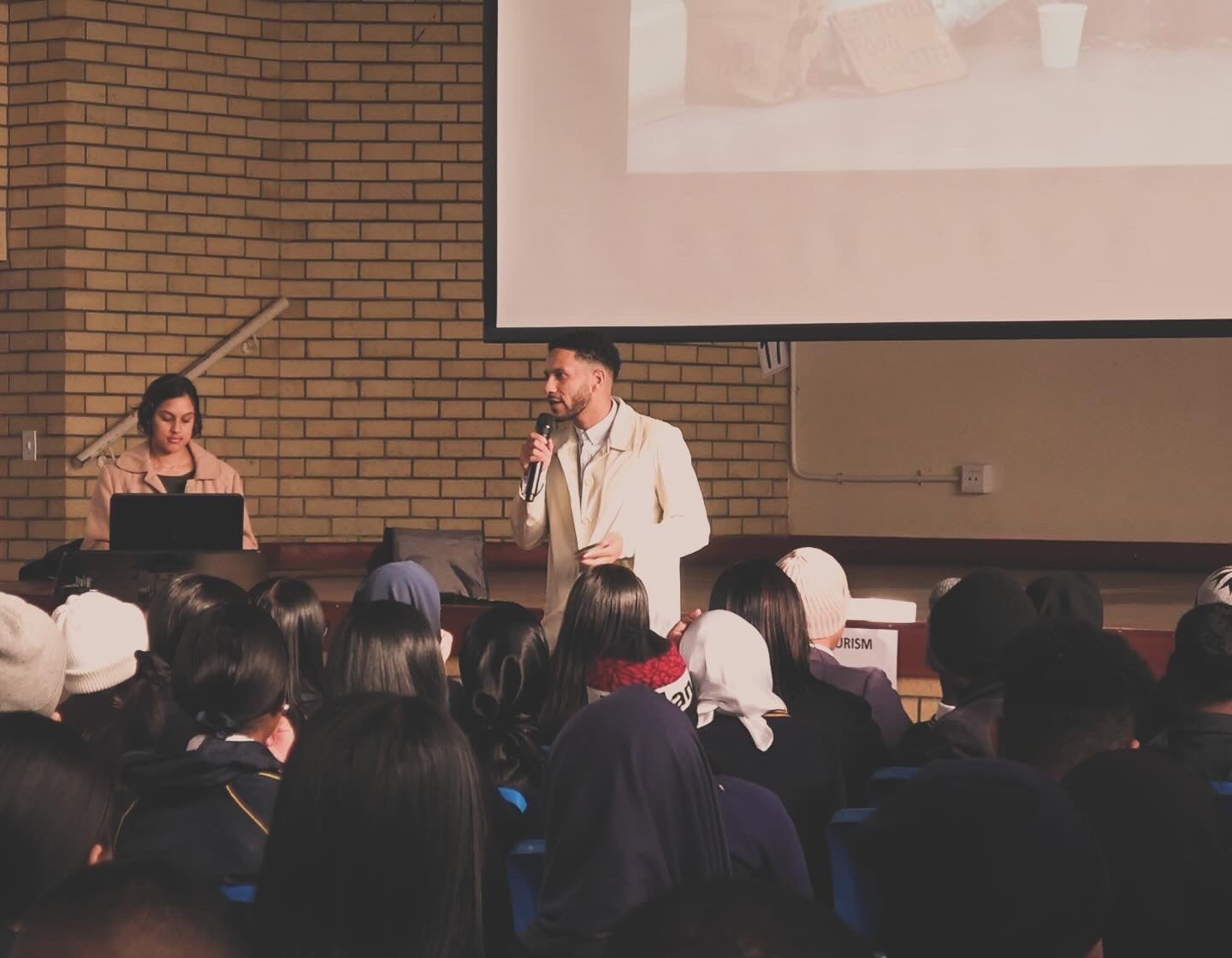 A ProVision speaker addressing a school hall filled with students